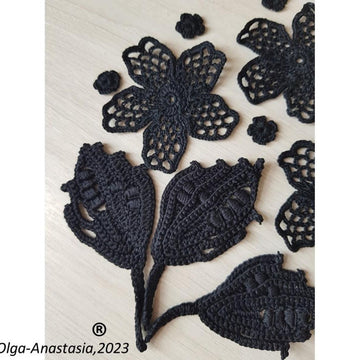Crochet composition of flowers and leaves in black