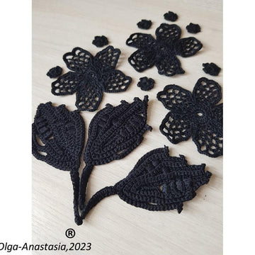 Crochet composition of flowers and leaves in black