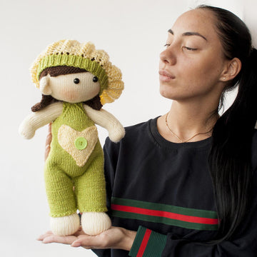 Baby doll in green overalls